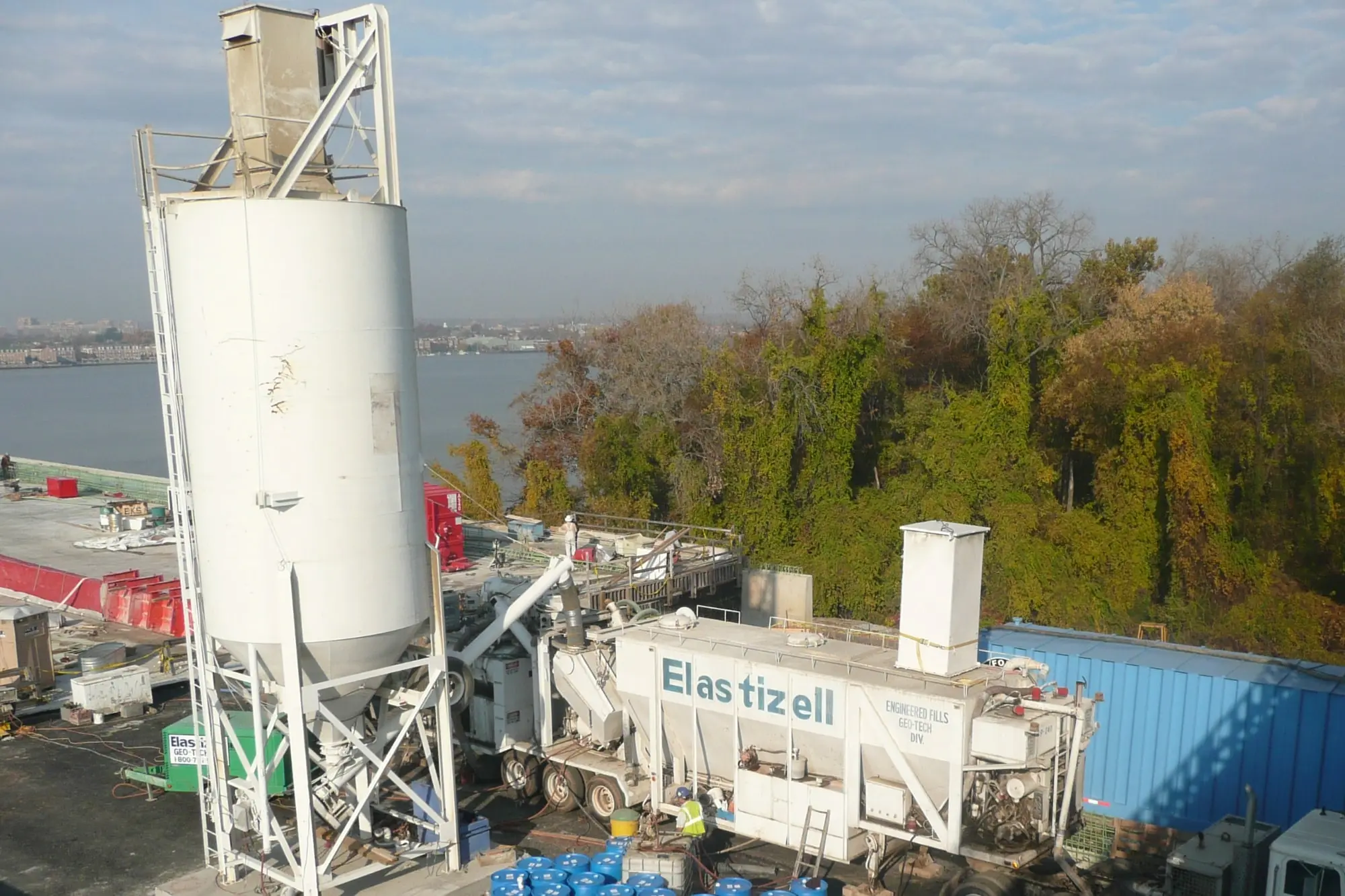 Elastizell Systems workers operating a lightweight cellular concrete plant at a construction job site